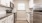 Kitchen with a bright window, stainless steel appliances, and white cabinetry